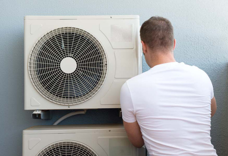 Man performing AC maintenance now since the spring season is here.