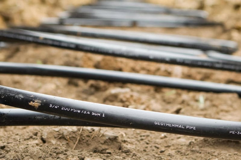 Workers Laying Geothermal Coils in an Underground Trench.
