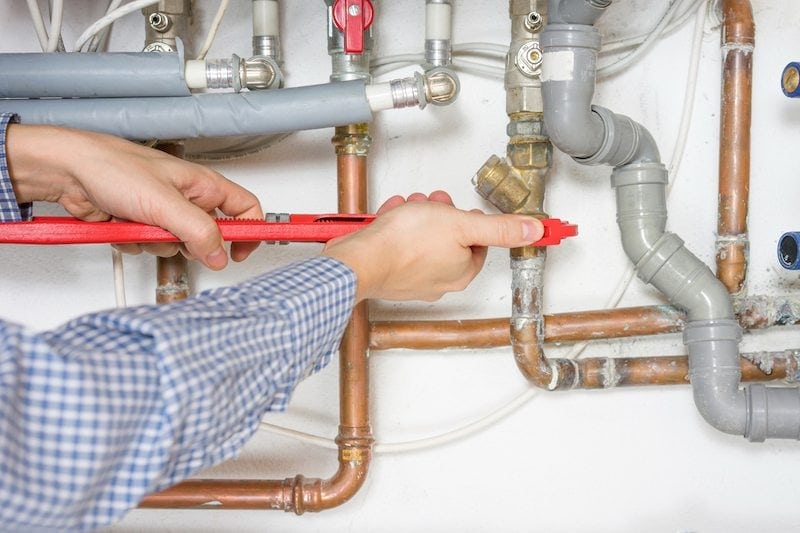 plumber fixing central heating system. Furnace leaking water in a home in Kalida