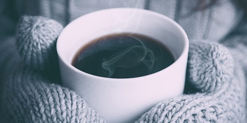 Person in mittens holding coffee